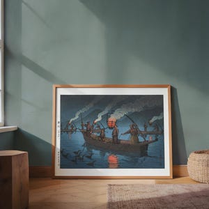 May include: Framed print of a Japanese woodblock print depicting a nighttime fishing scene. Several boats with figures are on the water, illuminated by lanterns and fires. The print has a dark blue and brown color palette.