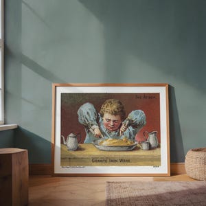 Può includere: Stampa vintage incorniciata intitolata "The Attack" con un bambino a tavola che taglia il cibo. La stampa include il testo "Granite Iron Ware" e una piccola teiera e brocca. L'opera d'arte è in una cornice di legno.