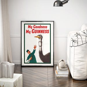 May include: Framed vintage Guinness advertisement featuring an ostrich and a man in a green uniform. The poster has the text "My Goodness My Guinness" in red and white. The artwork is displayed in a black frame.