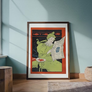 May include: A framed vintage poster with a woman reading a newspaper titled "High Life." The woman is wearing a green dress and seated in a chair. The poster has a red border and a dark brown frame. A small table with a cup and book is next to the woman.