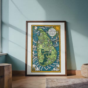 May include: A framed vintage-style map of Ceylon showing her tea industry, featuring a green island illustration surrounded by blue ocean, yellow borders, and decorative nautical elements with text labels for various cities and regions.