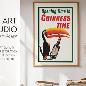 Puede incluir: Anuncio vintage de Guinness enmarcado, con un tuc&aacute;n sosteniendo una botella de Guinness. El p&oacute;ster tiene el texto "Opening Time is Guinness Time" en rojo y verde. La obra de arte est&aacute; en un marco de madera.