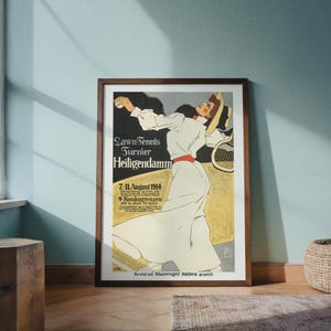 May include: A framed vintage poster advertising a Lawn Tennis Tournament in Heiligendamm. The poster features a woman in a white dress playing tennis, with text in German. The poster is in a dark brown frame.