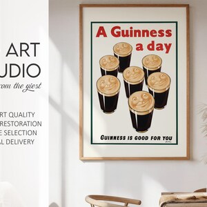 May include: A framed vintage Guinness advertisement poster. The poster features the text "A Guinness a day" in red, with smiling pints of Guinness. The text "Guinness is good for you" is at the bottom. The poster is in a wooden frame.