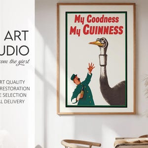 May include: Framed vintage Guinness advertisement featuring a cartoon of a man in a green uniform reaching up towards a large bird with a long neck. The text "My Goodness My Guinness" is in red. The artwork is from KG Art Studio.