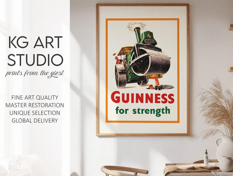 May include: A framed vintage Guinness advert. The poster shows a green steamroller with the word "GUINNESS" in red and "for strength" in green. The artwork is set against a cream background with an orange border. The frame is wooden.