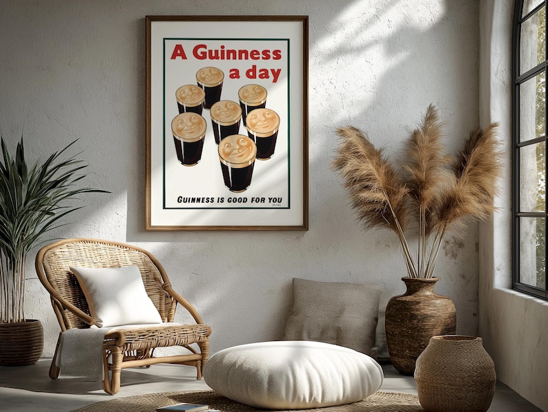 May include: A framed print with the text "A Guinness a day" and "Guinness is good for you." The print features six pints of Guinness. The print is in a room with a wicker chair, a white pillow, and a vase with dried plants.