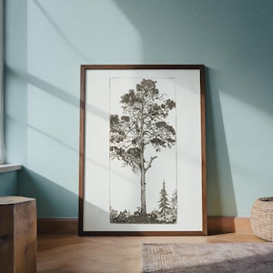 May include: A framed black and white print of a tall tree with detailed branches and foliage. The artwork is in a dark wood frame and leans against a light blue wall. A small tree is visible to the right of the main tree.