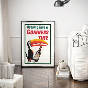Puede incluir: P&oacute;ster enmarcado con un tuc&aacute;n sosteniendo una botella de Guinness. El p&oacute;ster tiene el texto "Opening Time is Guinness Time" en rojo y verde. El tuc&aacute;n tiene un gran pico amarillo y naranja. El p&oacute;ster est&aacute; en un marco negro.
