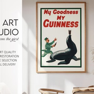 May include: A framed vintage Guinness advertisement. The poster features the text "My Goodness My Guinness" in red and white. An illustration shows a seal balancing a pint of Guinness on its nose, with a man in a green uniform.