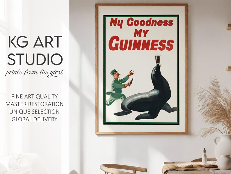 May include: A framed vintage Guinness advertisement. The poster features the text "My Goodness My Guinness" in red and white. An illustration shows a seal balancing a pint of Guinness on its nose, with a man in a green uniform.