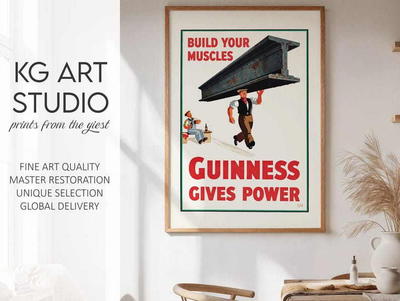 May include: A framed vintage Guinness advertisement print. The poster features a worker carrying a large steel beam with the text "BUILD YOUR MUSCLES" and "GUINNESS GIVES POWER" in red. The print is from KG ART STUDIO.