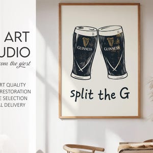 May include: A framed print featuring two Guinness pint glasses with the text "split the G". The print is in black and white with a cream-colored background. The print is from KG Art Studio.