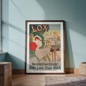 Könnte beinhalten: Gerahmtes Vintage-Poster mit dem Wort "LOX" in großen Buchstaben. Das Poster zeigt eine Illustration einer trinkenden Frau und eines Mannes an einem Tisch mit einer Flasche. Der Text unten lautet "TONI-APÉRITIF PAR EXCELLENCE KINA-LOXA, COCA, KOLA".