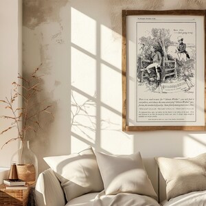 May include: A framed vintage illustration in a wooden frame. The black and white artwork depicts two men in a rural setting, with text below. The frame is rectangular and hangs on a neutral-colored wall, above a white sofa.
