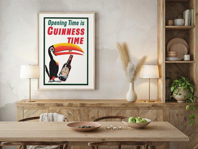 Puede incluir: P&oacute;ster vintage enmarcado de Guinness con un tuc&aacute;n sosteniendo una botella de Guinness. El texto dice "Opening Time is Guinness Time" en rojo y verde. El tuc&aacute;n tiene un pico amarillo y rojo. El p&oacute;ster est&aacute; en un comedor.