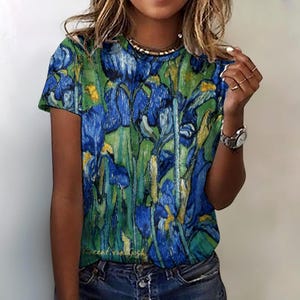 May include: A short-sleeved t-shirt with a floral design in blue, green, and yellow, inspired by Van Gogh's art. The artist's signature is visible. The top has a crew neck. The colour palette is vivid and artistic.
