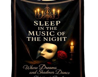May include: A black rectangular throw blanket featuring a gold chandelier, a white theatrical mask, a red rose, and a quill pen. The text reads: SLEEP IN THE MUSIC OF THE NIGHT, Where Dreams and Shadows Dance, and Christine & Raoul in gold lettering.