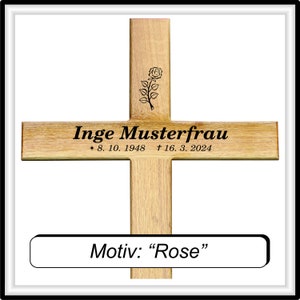 May include: A wooden cross with a rose design and the inscription "Inge Musterfrau * 8. 10. 1948 &dagger; 16. 3. 2024". The text "Motiv: "Rose"" is below the cross.