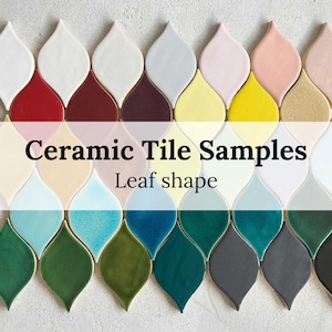 May include: Ceramic tile samples in a leaf shape. The tiles are arranged in rows, with each row featuring a different colour. The colours include white, red, burgundy, yellow, light blue, dark blue, green, and black.