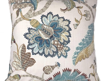 May include: Square throw pillow with a floral pattern in shades of blue, brown, and tan on a cream background. The design features large stylized flowers and foliage, creating a decorative accent for home decor.