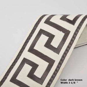 May include: Dark brown Greek key trim with a white background. The trim is 3 1/8 inches wide.