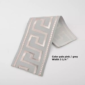 May include: Pale pink and grey trim with a Greek key design. The trim is 3 1/4 inches wide.