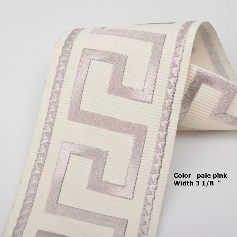 May include: Pale pink Greek key trim ribbon with a white background. The ribbon is 3 1/8 inches wide.