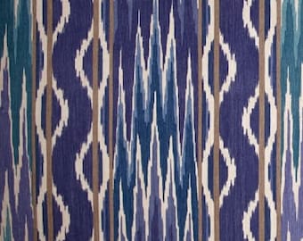 May include: A fabric with a blue and brown ikat pattern. The fabric has a white background with a repeating pattern of blue and brown lines and shapes.