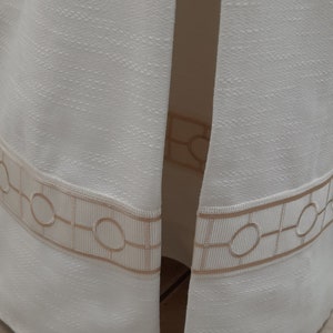 Pode incluir: Tecido branco com um padrão geométrico em cor creme. O tecido tem uma superfície texturizada e um brilho sutil.