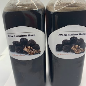 May include: Two glass bottles filled with a dark liquid, labeled "Black walnut Bath". Each bottle has a white label with a black walnut illustration and the text "By @walnut.botanica".