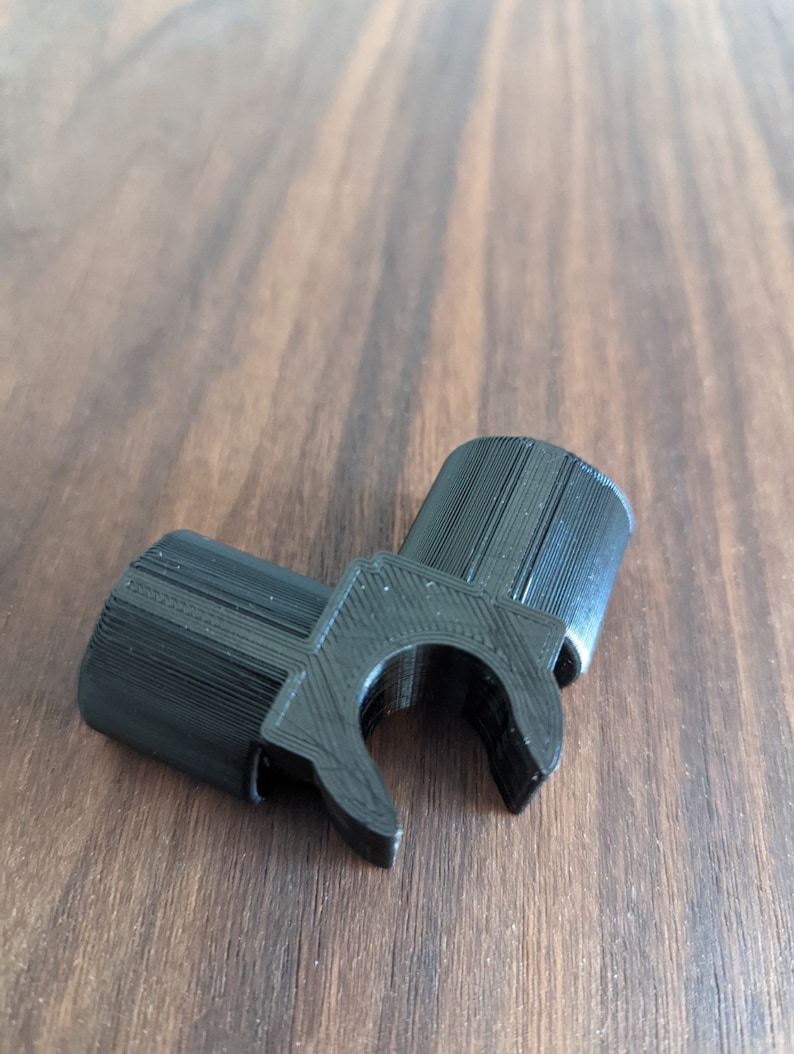 May include: Black plastic 3D printed corner bracket with a clip on one side.