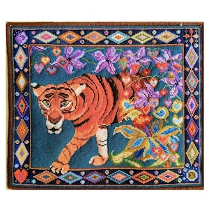 May include: A hand-stitched tapestry featuring an orange tiger with black stripes, walking towards the left. The tiger is surrounded by colourful flowers and hearts on a teal background, framed by a decorative border.