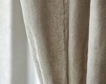May include: Close-up of a beige linen curtain with a textured weave. The fabric is soft and drapes beautifully.