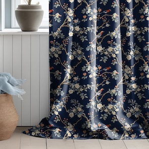 Könnte beinhalten: Blauer Vorhangstoff mit einem floralen Muster mit weißen Blüten, grünen Blättern und roten Vögeln.