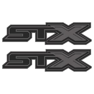 May include: Two STX logo decals. The logos are in a dark gray color with a lighter gray outline. The letters are stylized and have a geometric design. The decals are for sports equipment.