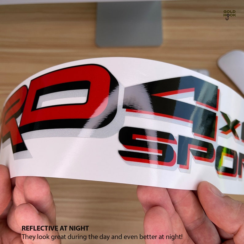 May include: A close-up of a red and black reflective decal with the text "4x4 Sport" and the words "Reflective at Night" and "They look great during the day and even better at night!" printed below.
