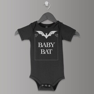 May include: Black baby onesie with a white bat graphic and the text "BABY BAT" in a white box.