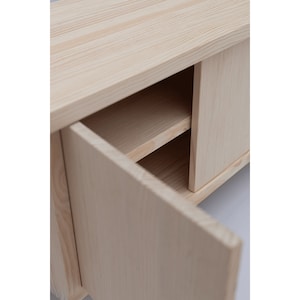 May include: A light wood cabinet with two doors, one open and one closed. The cabinet has two shelves inside.