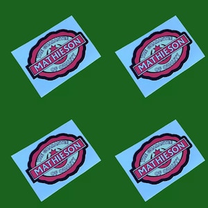 May include: Four white square stickers with a black circle containing a red and white circle with the text "THE GUARANTEE MATHIESON OF QUALITY" in black.