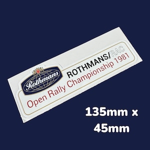 Op de afbeelding: Witte sticker met een rood en blauw logo met de tekst "Rothmans" en de tekst "Rothmans/RAC Open Rally Championship 1981". De sticker is 135 mm x 45 mm.