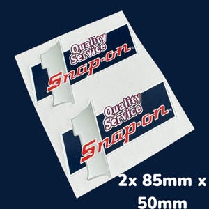 May include: Two white stickers with a blue and red Snap-on logo. The logo says "Quality Service Snap-on" and features a number one. The stickers are 85mm x 50mm.