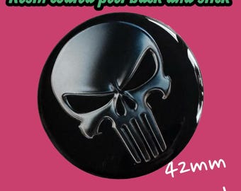 May include: A round, black resin-coated sticker with a peel-back adhesive. The sticker features a silver skull design. The text "Resin coated peel back and stick" is at the top, and "42mm round" is at the bottom.