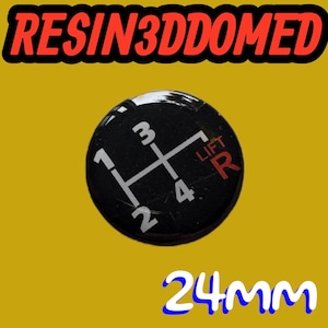 May include: A black gear shift knob with a white shift pattern, including numbers 1, 2, 3, 4, and R for reverse. The text "LIFT" and "R" are in red. The text "RESIN3DDOMED" is in red. The knob is 2.4cm in diameter.