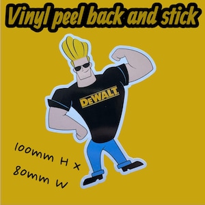 May include: A vinyl peel-and-stick sticker featuring a cartoon character with blonde hair, sunglasses, and a black t-shirt with the "DEWALT" logo. The sticker is on a yellow background and measures 100mm high by 80mm wide.
