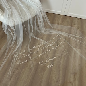 Può includere: Un velo di tulle bianco con il testo "I will to the farthest lace on earth, I can travel all the sad, you see 'Cause I know you're there with me" e "Tim & Mare 17.02.24" scritto su di esso.