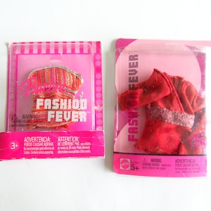 May include: Two Barbie Fashion Fever doll outfits in their original packaging. One package contains a red and orange top with silver accents. The other package contains a red outfit with lace trim. Both packages are pink and have the words "Fashion Fever" printed on them.