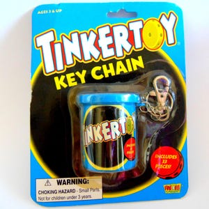 May include: A blue and black TinkerToy Key Chain package. The package includes a small blue container with the TinkerToy logo and a metal key ring. The package also includes 33 pieces. The text "AGES 3 & UP" is at the top.