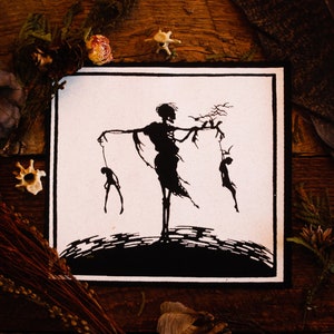May include: Black and white illustration of a skeletal figure holding two smaller figures by strings. The skeletal figure is standing on a dark, textured surface.