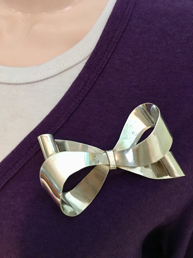 Large sterling silver bow brooch with curling ribbon ends